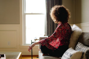 Silence for self care | Life Coach Nancy Stevens | woman sitting on couch near window