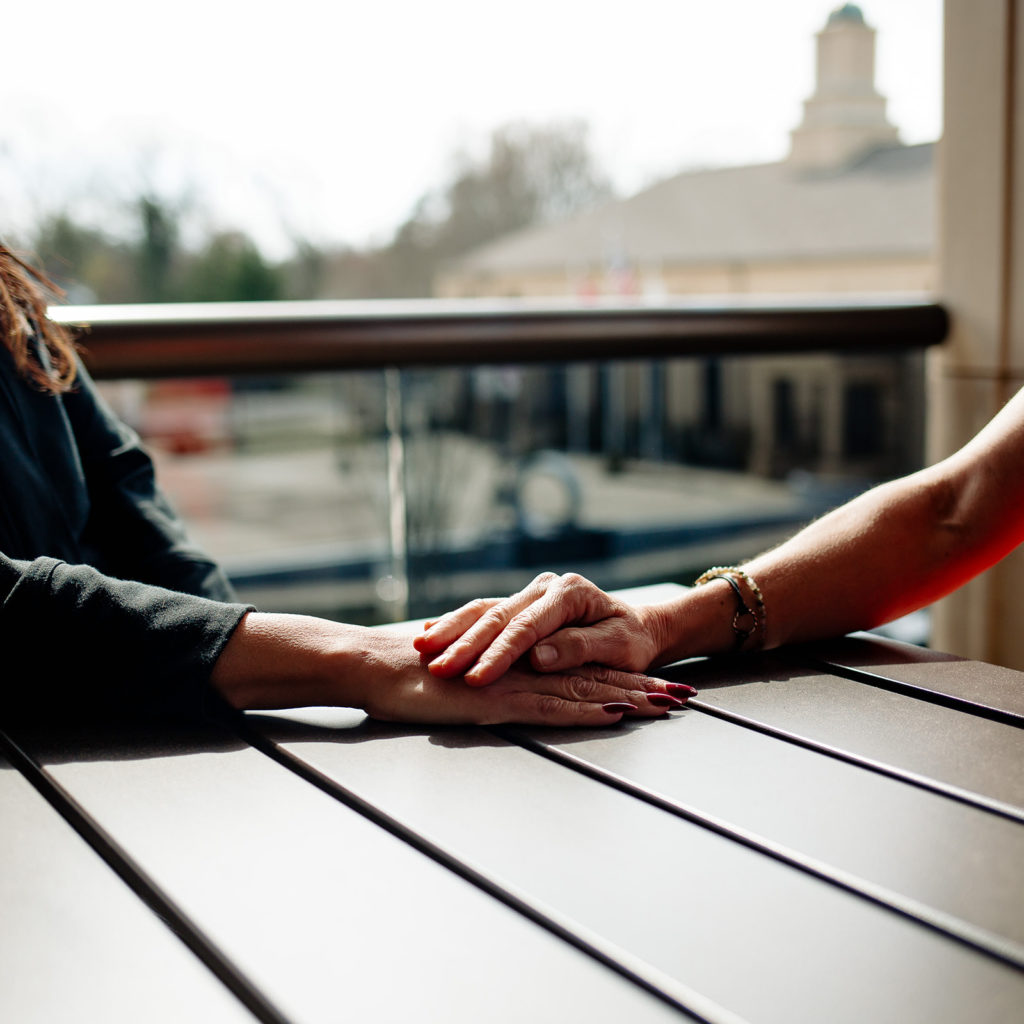 Hand comforting another person