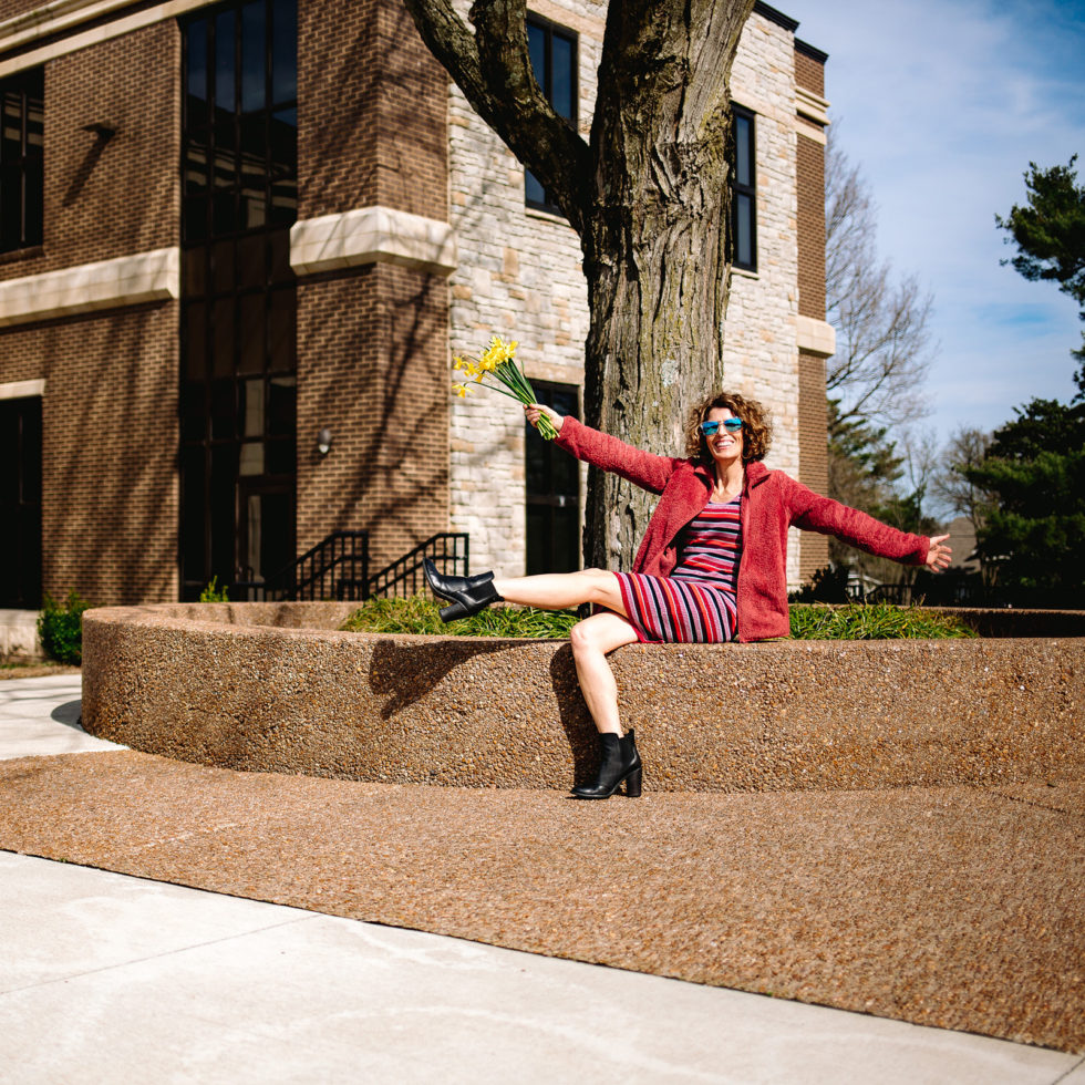 woman wearing red jacket sitting on platform