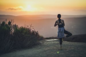 woman doing yoga pose in park at golden hour